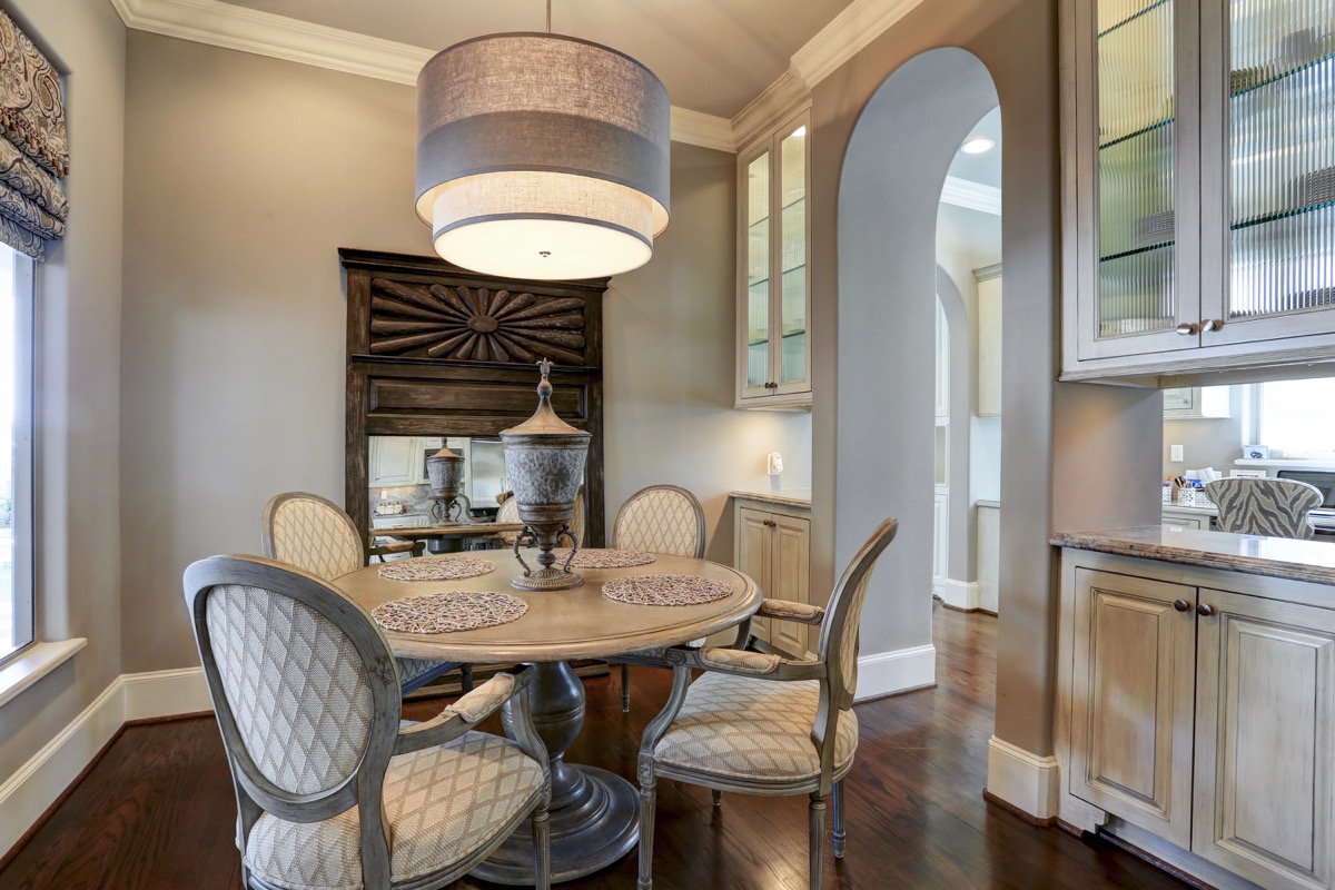 Breakfast room is open yet cozy with glass cabinetry that lets light through