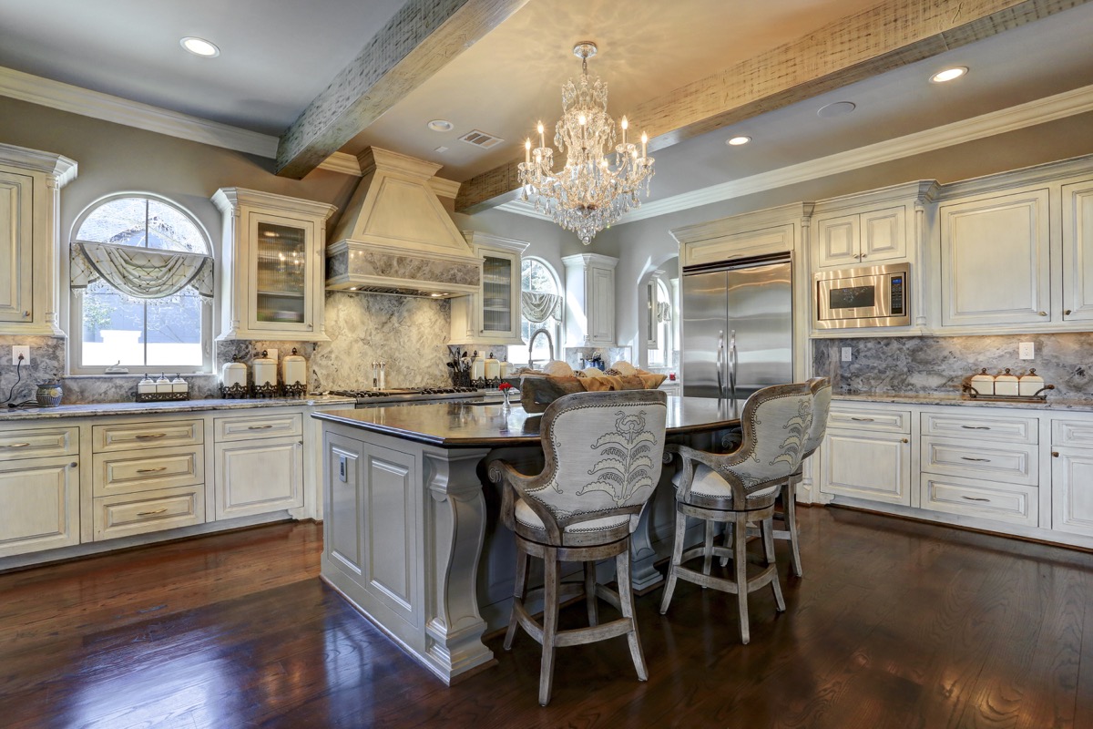 Kitchen has state of the art appliances, carrara marble countertops, black leathered granite island, and antiqued beams
