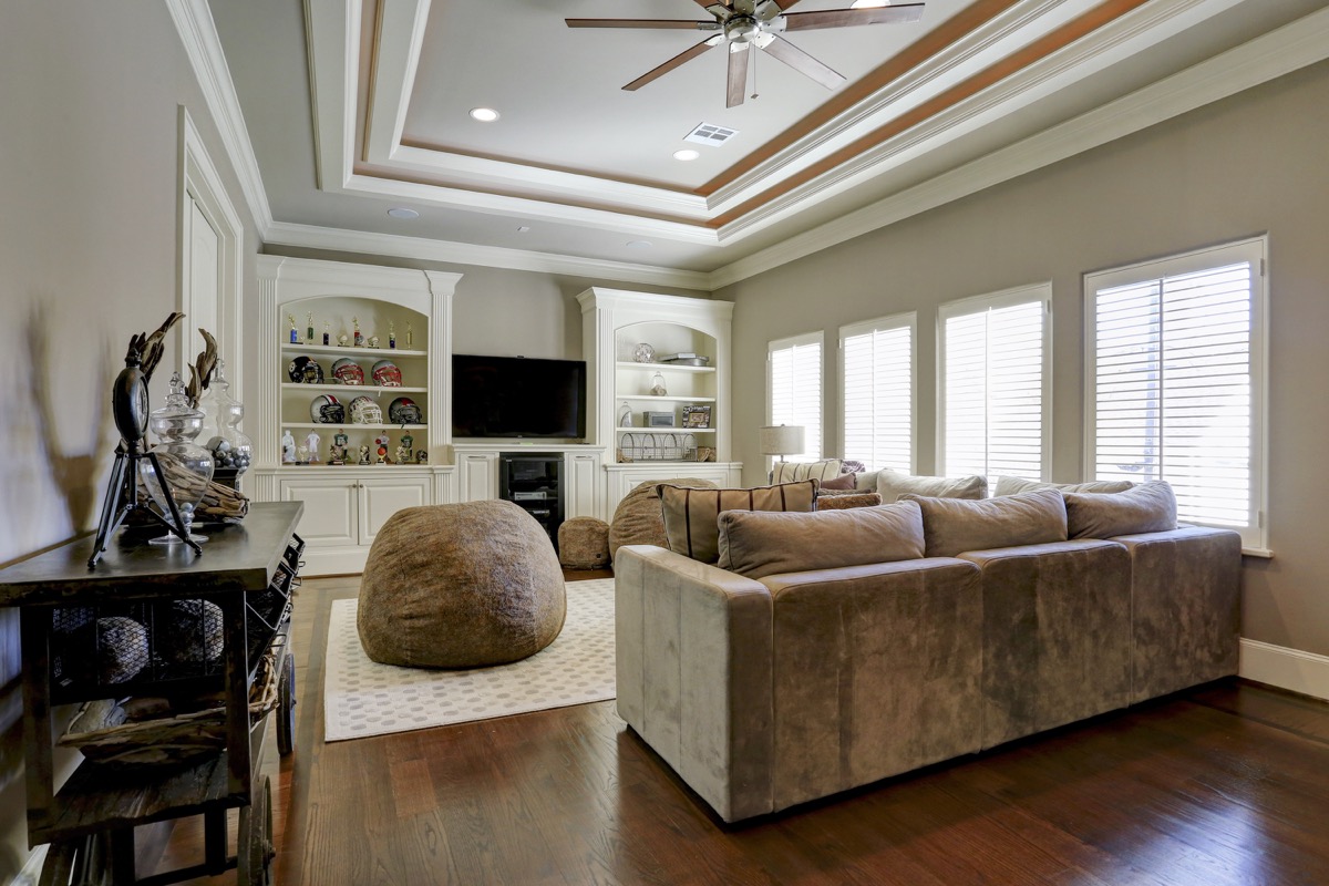 Game room overlooks the pool and features recessed ceiling and built-in cabinetry