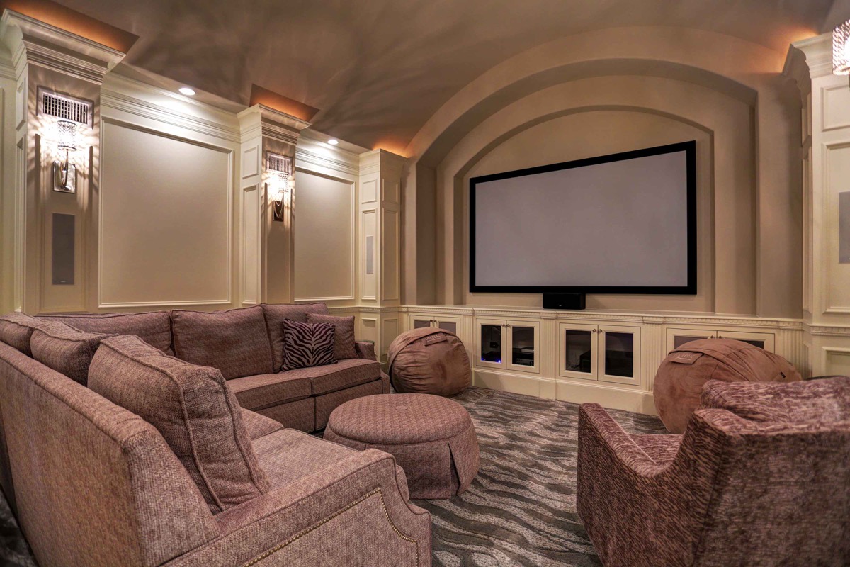 Media room with barrel-vaulted ceiling is equipped with surround sound, projector, and extra insulation in the walls